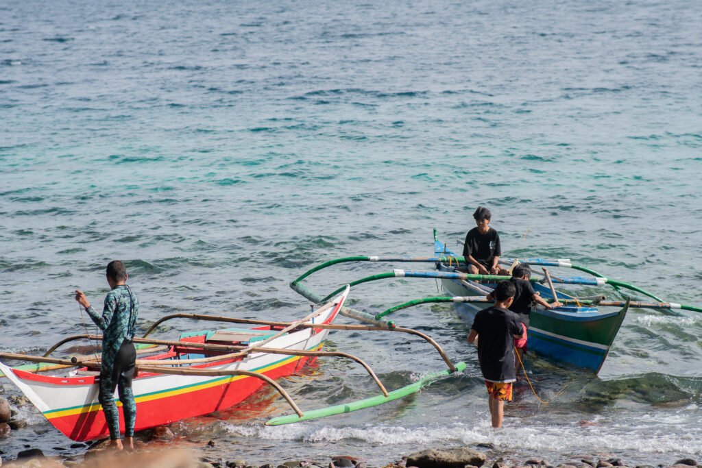 Local fishermen in Biliran preparing their banca boats on the shoreline for traditional fishing.