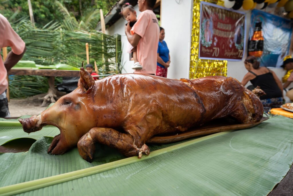 Traditional Lechon Baboy celebration in the Philippines, featuring a roasted pig prepared for a family feast.