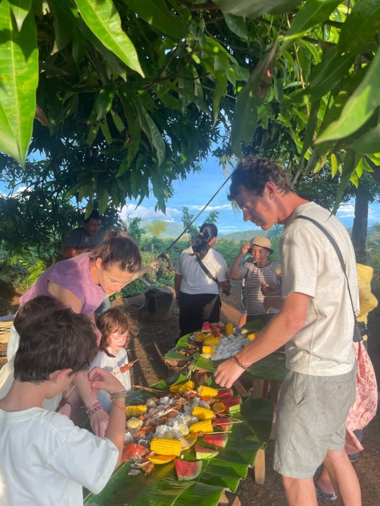 Travelers and locals sharing a traditional Filipino Boodle Fight meal outdoors in Biliran.